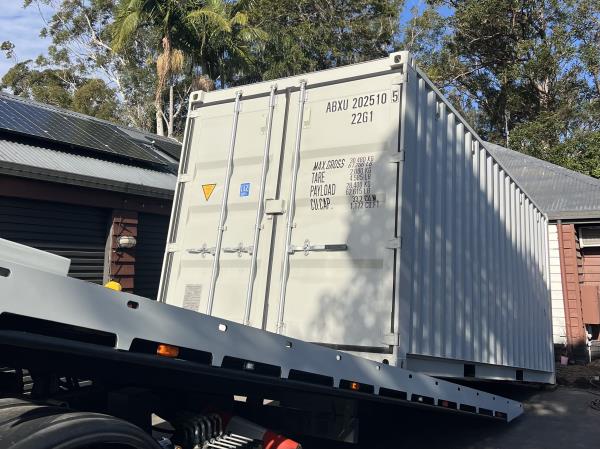 blue storage container unloading from removal vehicle