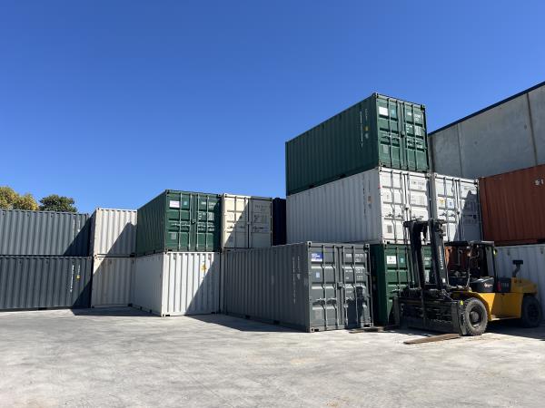 shipping containers being bulk stacked on top of each other