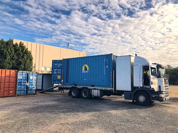 unloading of storage container from the back of a transport vehicle